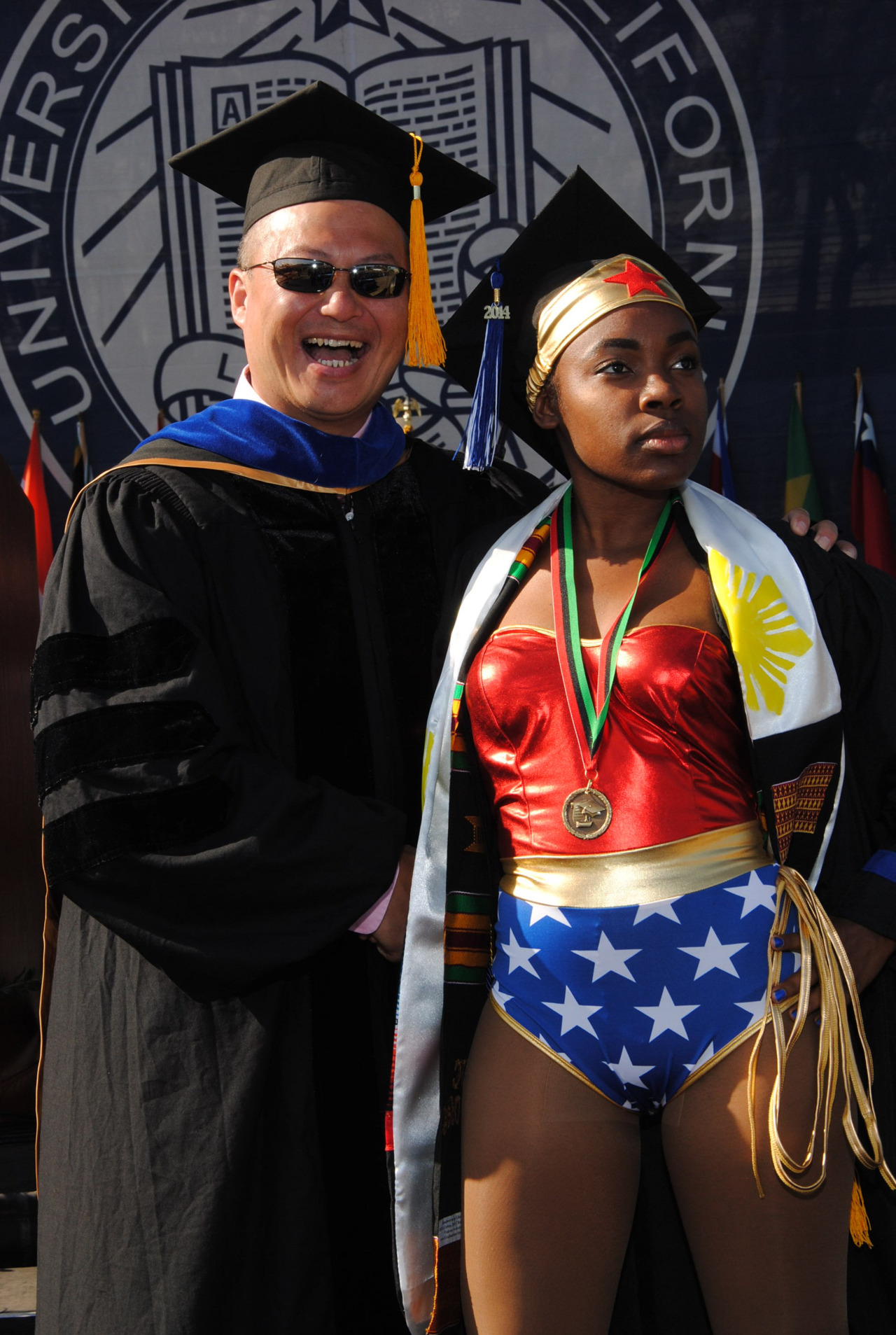 Woman wears full wonder woman costume under her graduation robe