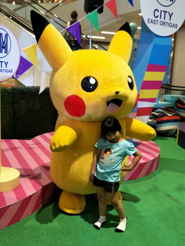 child posing with pikachu at KidCon
